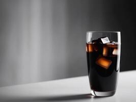 Glass with dark soda and ice with blurred background. photo