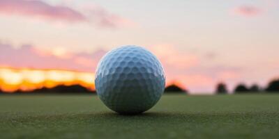 A Golf Ball Resting on the Green with a Sunset in the Background. photo