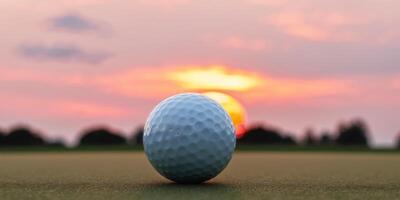 A Golf Ball Resting on the Green with a Sunset in the Background. photo