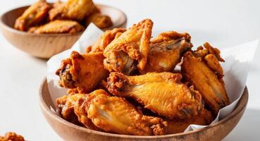 Crispy Fried Chicken Wings in a Wooden Bowl. photo