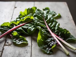 Close up image of fresh chard leaves on wooden table. photo