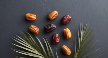 Dates and Palm Leaves on a Dark Slate Background. photo