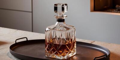 Crystal whiskey decanter resting on a wooden tray its contents glowing in the light of a nearby fire. photo