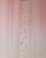 Elegant water droplets on a soft pink background. photo