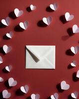 Valentines Card Mockup With Envelope And Small Paper Hearts On Red Background Top View. photo