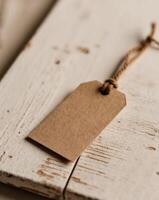 Rustic Kraft Paper Tag With String Loop on Textured Wood Surface in Natural Light. photo