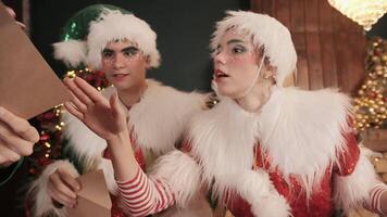 Christmas elves sort through children's letters and discuss them video