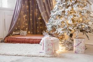 A Christmas tree sprinkled with artificial snow and a tent decorated with a luminous garland in the New Year's interior. Background for New Year wallpapers and postcards. photo