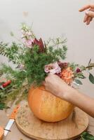Creating a floral composition in a pumpkin. Making decor with your own hands. photo