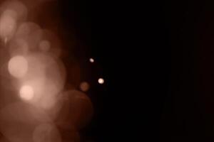 Blurry garland lights on a dark background. Festive Christmas and New Year background. Soft focus. Image toned in color of 2025 year - Mocha Mousse photo