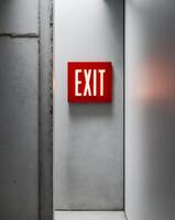 A red exit sign is seen in a hallway photo