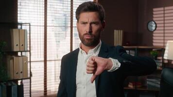 Portrait at office angry sad serious frown Caucasian man business male company worker problem trouble bad attitude businessman guy looking at camera showing thumb down no not finger dislike negative video
