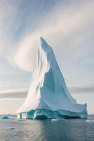 An iceberg floating in the ocean with a large white tip photo