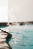 A man standing in front of a pool with steam coming out photo