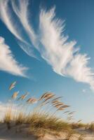 A sand dune with some clouds in the sky photo