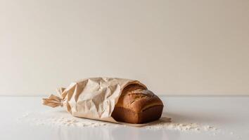 A loaf of bread in a paper bag on a white surface photo