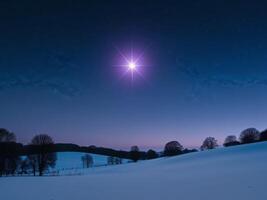 A star shines brightly in the sky over a snowy field photo