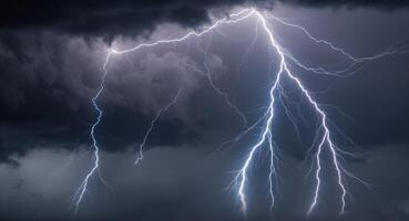 Lightning strikes over a dark sky with clouds photo