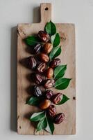 Dates on a cutting board with leaves photo