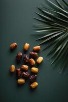 Dates and palm leaves on dark background top view photo