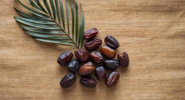 Dates and palm leaf on a brown canvas photo