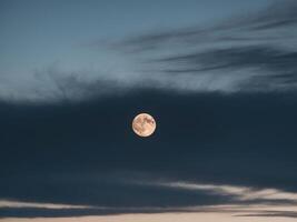 The moon is seen through the clouds in this photo