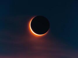 The eclipse is seen through the clouds photo