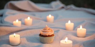 A cupcake sitting on a blanket surrounded by candles photo