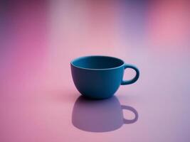 A blue coffee cup on a table with a pink and blue background photo