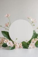 White oval frame with pink flowers and leaves on a white background photo