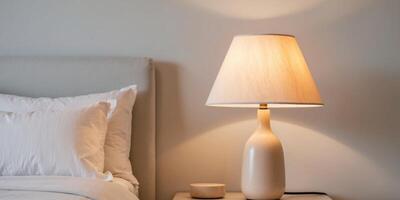 A white bed with a lamp on top of it photo