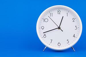 Clock telling time and working on time photo in studio on blue background