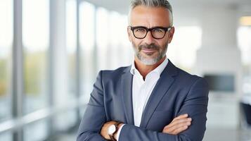 A man in a suit and glasses standing in an office photo