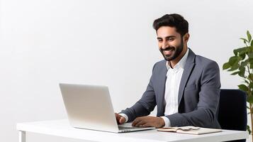A man in a suit is sitting at a desk with a laptop photo