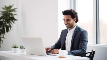 A man in a suit is sitting at a desk with a laptop photo