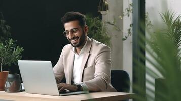 A man in a suit is sitting at a desk with a laptop photo