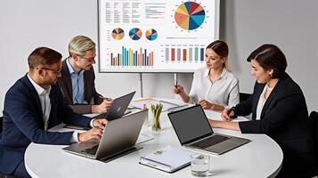 A group of business people sitting around a table with laptops photo