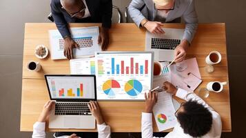 Business people working at a table with graphs and charts photo
