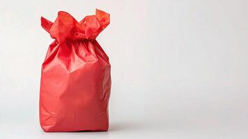 A red gift bag sitting on a white surface photo