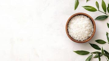 White rice in bowl on white background with green leaves photo