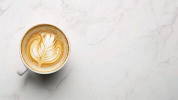 A cup of coffee with a leaf pattern on top of a marble surface photo