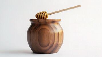 A wooden jar with a wooden stick and honey photo