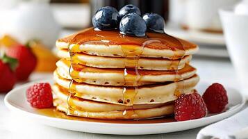 A stack of pancakes with syrup and berries photo