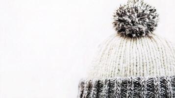 A close up of a knitted hat with a pom pom photo