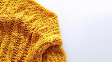 A yellow sweater on a white surface photo