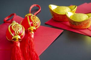 Chinese New Year decoration with golden ingots and Chinese New Year balls on red packets photo