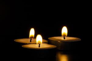 Three candles shining in the dark with customizable space for message, text or ideas. Copy space and candles concept photo