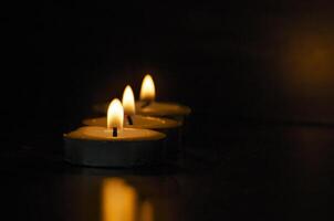 Candles shining in the dark with customizable space for message, text or ideas. Copy space and candles concept photo