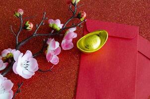 Top view of pink flower, golden ingot and Chinese New Year red packet photo