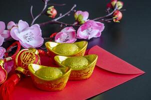 Golden Ingots on top of Chinese New Year red packet. Chinese New Year celebration photo